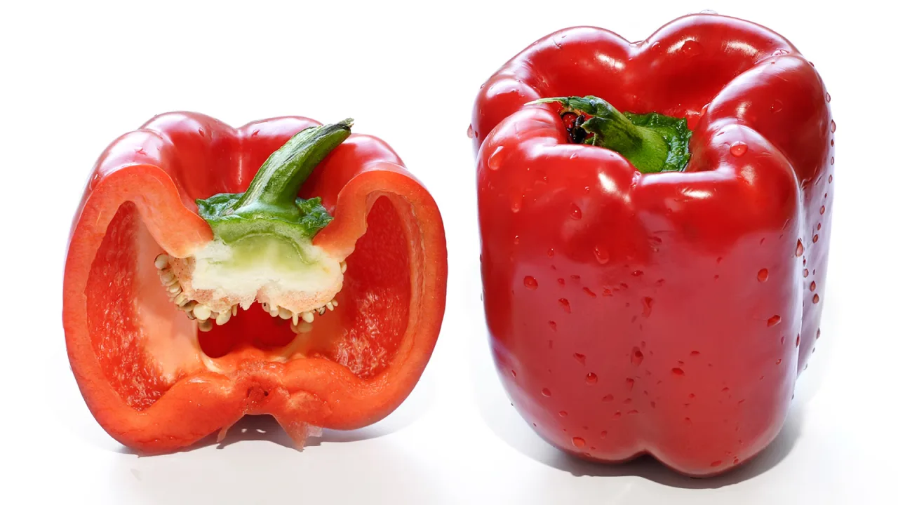 Punainen paprika kokonaisena ja halkaistuna